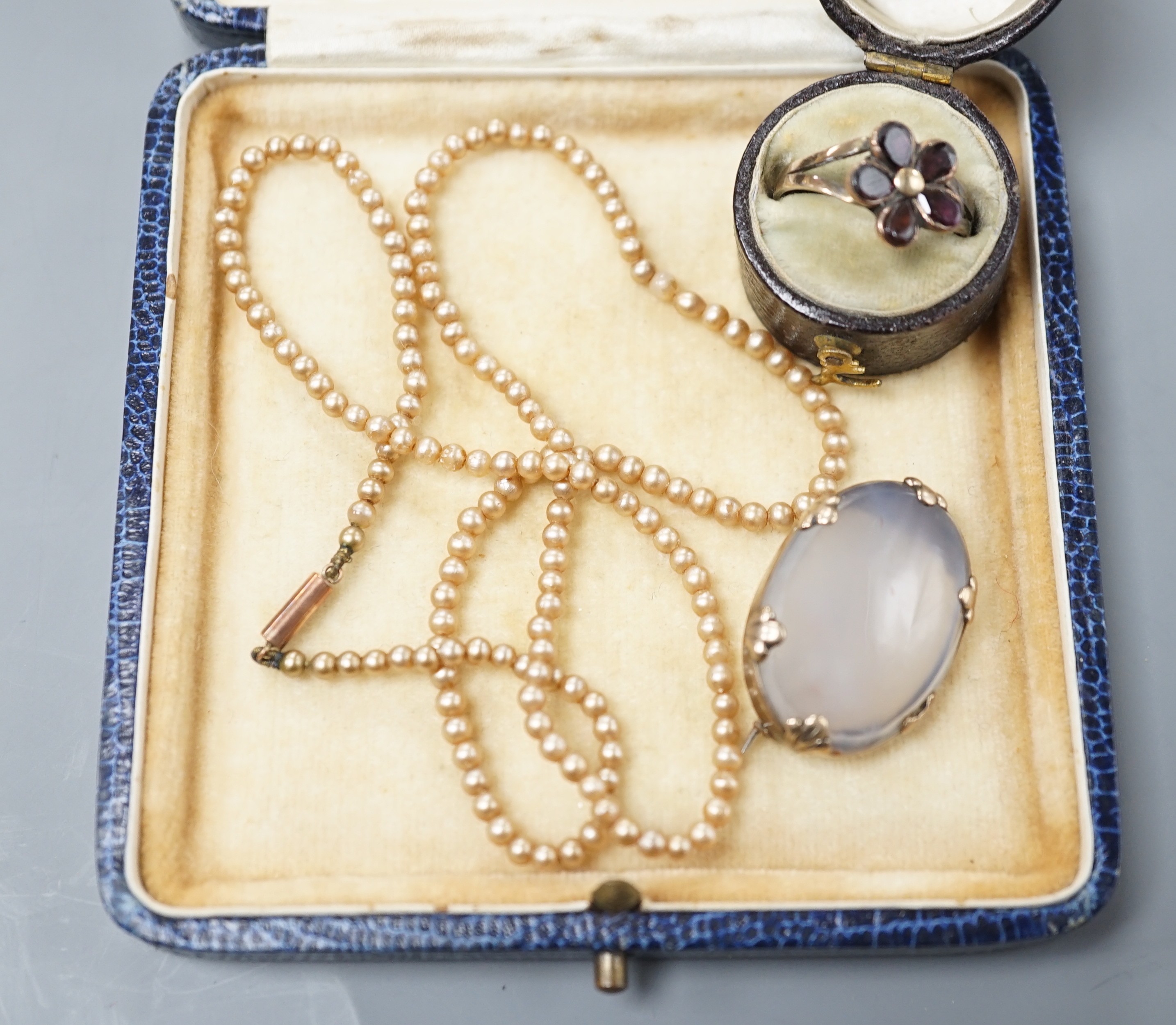 A simulated seed pearl necklace, oval brooch set with carnelian and a garnet set dress ring.